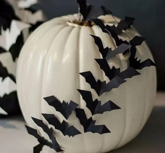 a white pumpkin decorated with black paper bats is a stylish idea for Halloween and will make your absolutely happy with how easy it is to make it