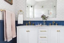 an eclectic bathroom in navy, grey and pink with gilded touches shows off the beauty of vintage and boho styles