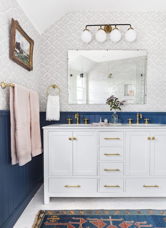 an eclectic bathroom in navy, grey and pink with gilded touches shows off the beauty of vintage and boho styles