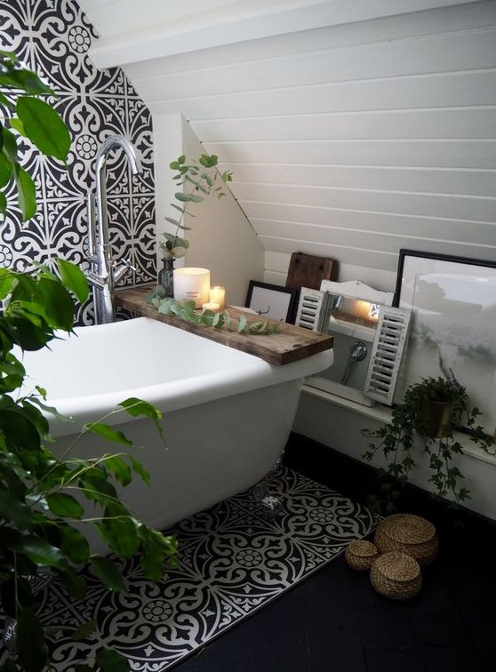 an eclectic bathroom with black and white art deco tiles, with boho touches like wicker containers and potted greenery and decor