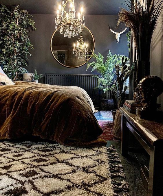 an eclectic bedroom with black walls and a ceiling, a bed with dark bedding, a fireplace with books and various decor, potted statement plants