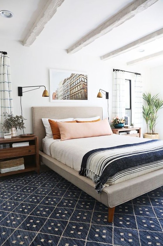 an eclectic sleeping space with an upholstered bed, wooden mid century nightstands, vintage glam lamps and much more