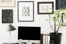 an elegant Scandinavian home office with a black trestle desk, a leather chair and a black and white gallery wall