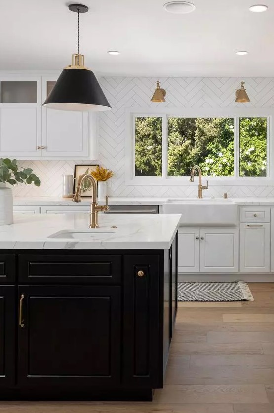 an elegant and refined kitchen with white shaker cabinets, a black kitchen island, white stone countertops and a white chevron tile backsplash