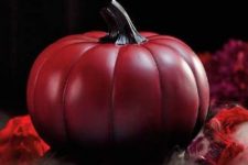an ombre red to black pumpkin with a black stem is a cool and chic Halloween decor idea to rock