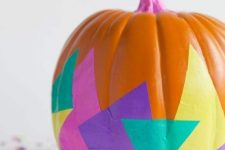 an orange pumpkin with a pink stem and super bold paper decoupage is a catchy idea for a colorful Halloween party