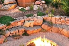 an outdoor space with rocks and a built-in bench of them, a fire pit in the center and a hot tub is a lovely idea