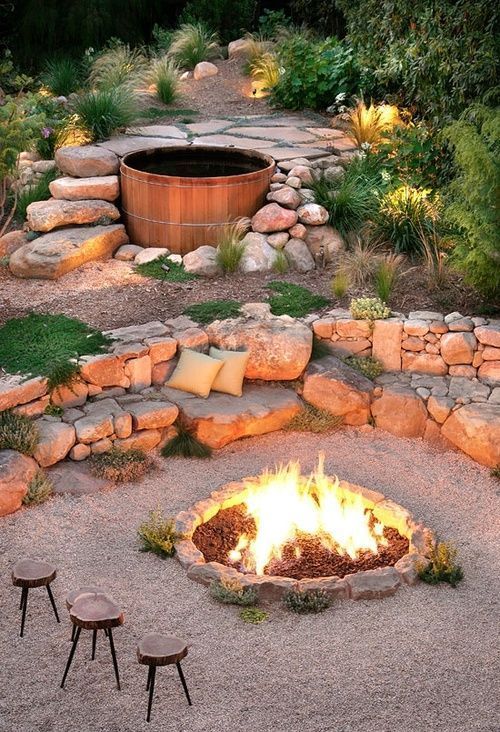 an outdoor space with rocks and a built in bench of them, a fire pit in the center and a hot tub is a lovely idea