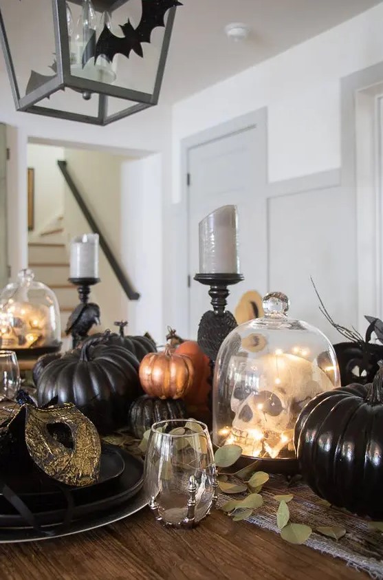 black, orange and copper faux pumpkins plus a skull in a cloche make up a stylish and fun centerpiece for Halloween