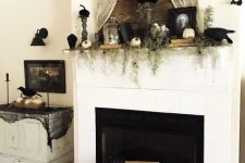 chic vintage fireplace styling with greenery, pumpkins, bats, portraits, books and some spider web here and there