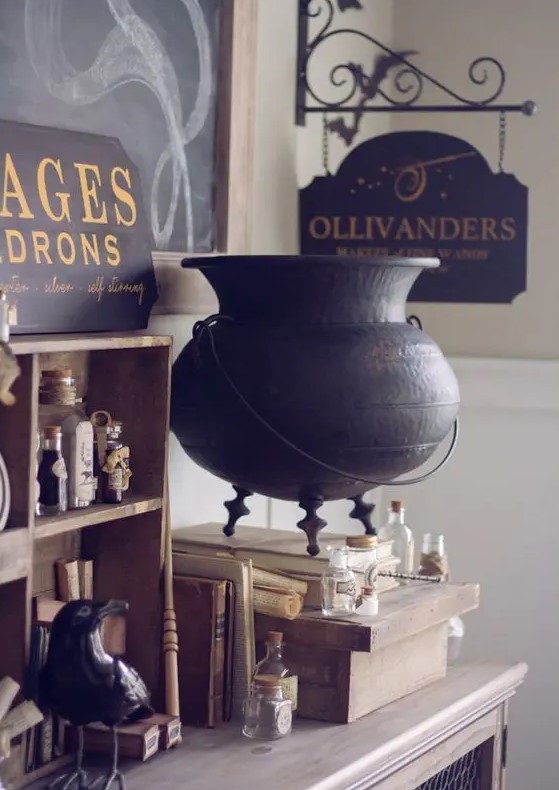lovely vintage Halloween decor inspired by Harry Potter books with a wooden shelf, bottles and a bird, a witch's cauldron, some signs