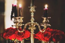 red roses pair up beautifully with deep purple and black candles in a gold candelabra for a Halloween decoration