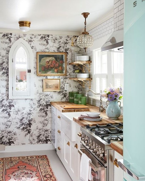 traditional white cabinets with butcherblock countertops are combined with a floral wall, a glam lamp and a boho rug