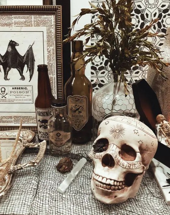 vintage Halloween decor with a patterned skull, poison bottles, greenery, vintage signs and artworks is easy to recreate yourself