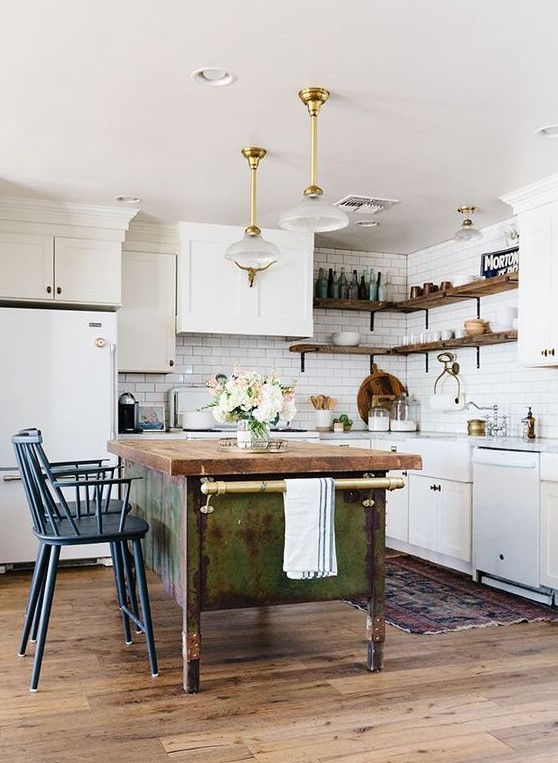 white cabinets paired with a shabby chic wooden kitchen island and vintage blue stools plus refined pendant lamps