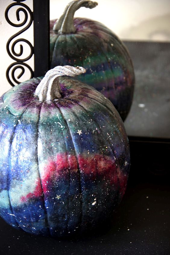 a beautiful blue, pink, grey and purple galaxy pumpkin with little white and silver stars and constellations for Halloween