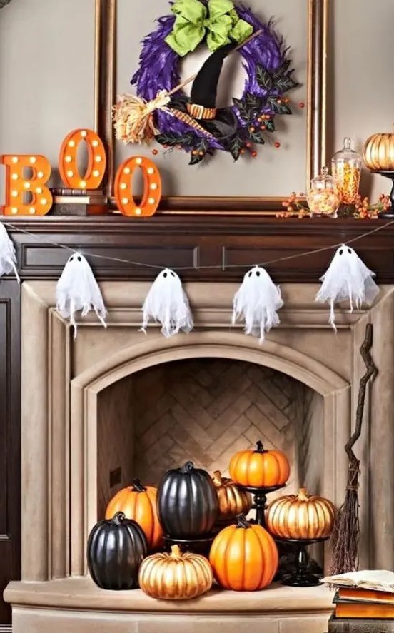 a cheesecloth ghost garland over the fireplace and a pumpkin display inside it are a great combo for Halloween