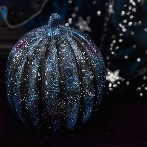 a black and navy galaxy pumpkin with tiny white spot stars is a very stylish decoration for Halloween