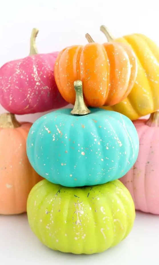 neon blue, green, orange, pink and yellow pumpkins with gold splatters are fantastic for Halloween decor