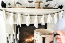06 a Halloween mantel with black bats in cloches, blackbirds, a ghost garland of cheesecloth and a chic candelabra