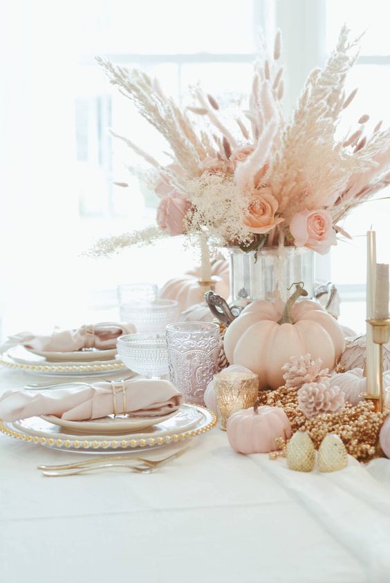 a fab pastel Thanksgiving tablescape with chargers with pearls, blush napkins, blush blooms, pampas grass and blush pumpkins