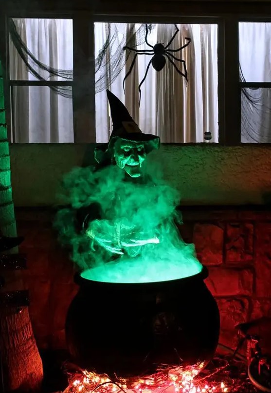 a witch cauldron prop wih additional green lights and some lights under it is a cool solution for outdoor Halloween decor