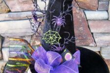 a black velvet witch’s hat with purple bows and ribbons, spiders and spiderwebs, branches and bold polka dots is a cool decoration for Halloween