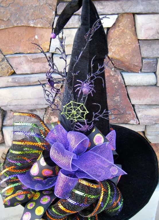 a black velvet witch's hat with purple bows and ribbons, spiders and spiderwebs, branches and bold polka dots is a cool decoration for Halloween