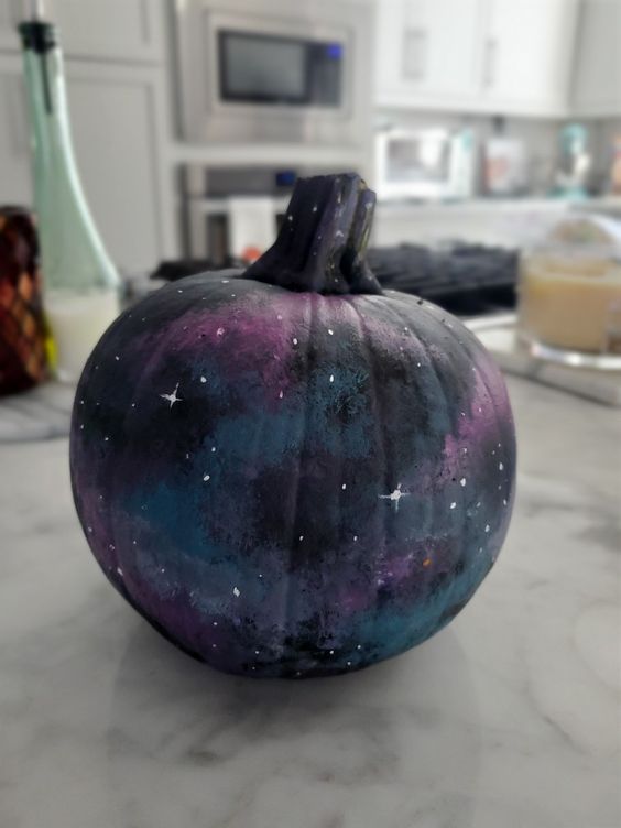 a fabulous black, blue, grey, purple galaxy pumpkin with tiny white stars painted is amazing for Halloween decor