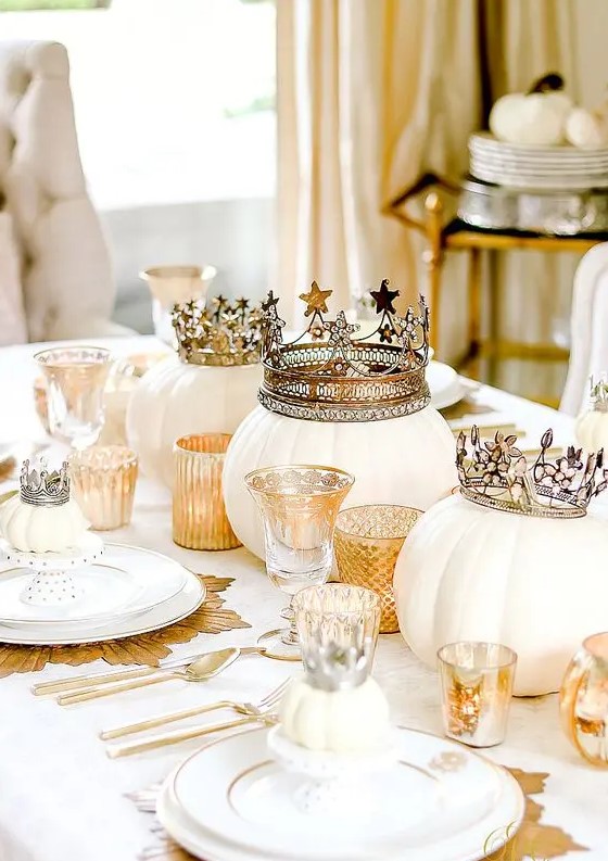 a fabulous glam Thanksgiving tablescape with white pumpkins with crowns, gold chargers and candleholders, mini pumpkins with crowns