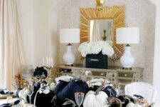 08 a glam Thanksgiving tablescape with large black and white velvet pumpkins, gold chargers, cutlery and candleholders plus black napkins