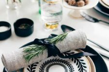 11 a large black plate, a gilded one, a black and white printed plate on top and a burlap napkin with greenery for a chic Thanksgiving table