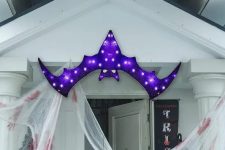 14 a bold and pretty purple bat marquee light over the entrace instead of a wreath or another Halloween door decoration