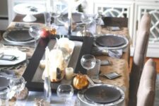 14 a modern and chic Thanksgiving tablescape with a candle centerpiece, printed and black plates, polka dot placemats is amazing