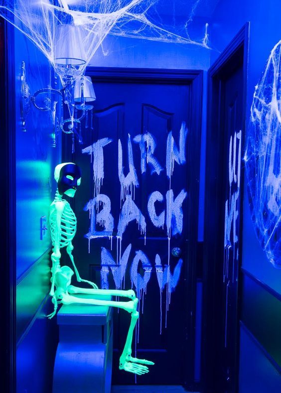 a bold blue space with a neon green skeleton and scary lettering is a gorgeous idea for your Halloween party