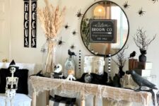 15 witch entryway styling with a console with blackbirds, spiders, a broom and witches’ hats over the table and some skeletons