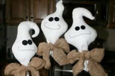 16 some tabletop ghosts made of white fabric, black buttons and burlap bows