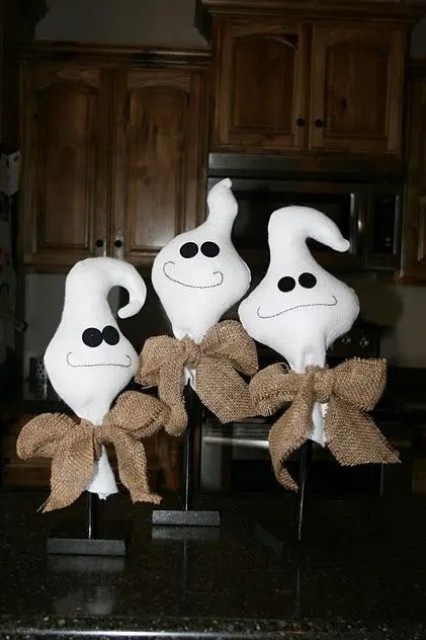 some tabletop ghosts made of white fabric, black buttons and burlap bows