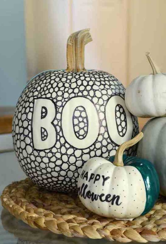 a super cool black and white pumpkin made with a sharpie and a green, black and white one made using a sharpie and some paint