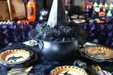 17 witches-inspired table decor with printed plates, a cauldron covered with a witch’s hat with spiders is cool for Halloween