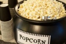 18 a black cauldron with popcorn is a cool way to serve this treat and it’s very Halloween-inspired and cool