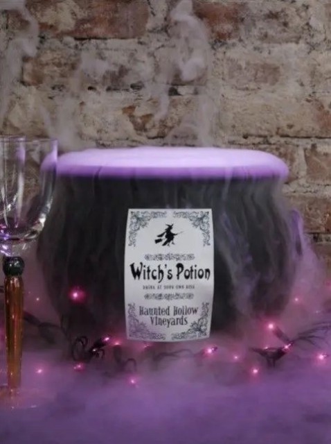 a cauldron with purple fog potion and lights is amazing and very eye-catchy for Halloween decor