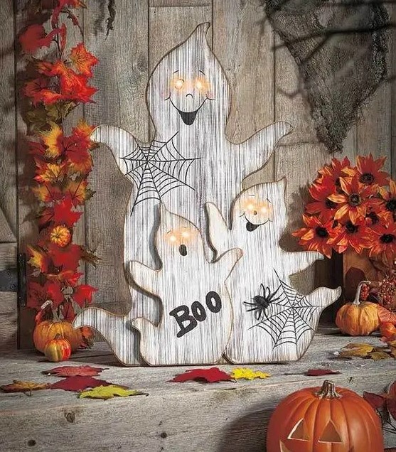 wood cut ghosts with webs, letters and lit up eyes for outdoor or indoor rustic decor at Halloween