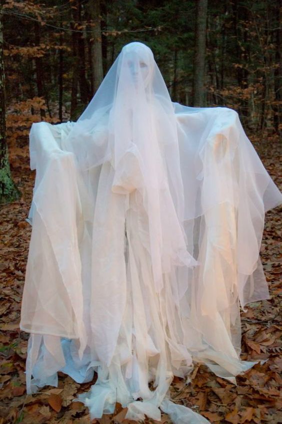 a beautiful and scary outdoor ghost decoration made with noodles, a mask, sheer white fabric and a T frame is wow