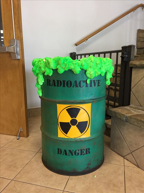 a green barrel with neon green radioactive waste is a gorgeous Halloween decoration that you can easily DIY