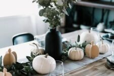 20 a modern Thanksgiving tablescape with a burlap runner, black plates and pots, pumpkins, greenery in a black vase is very chic
