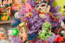 21 a lilac Halloween tree decorated with non green, yellow and pink monster decor and masks is wow