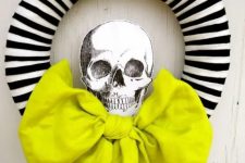 23 a modern Halloween wreath with a striped form, a neon green bow and a printed skull is a lovely and easy to DIY idea