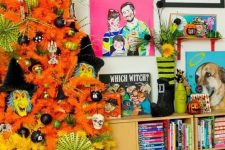 25 a neon orange and yellow Halloween tree decorated with black, green ornaments, monster masks and skulls is fun