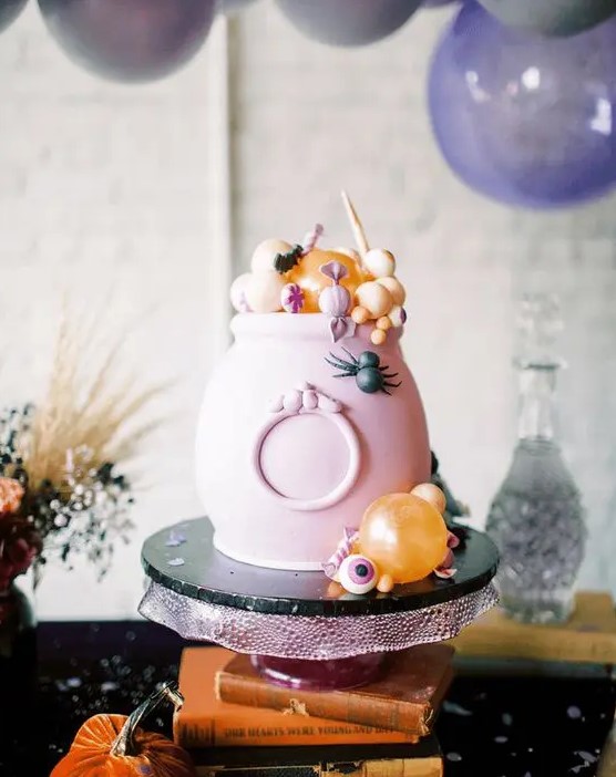 a pink cauldron with candies and sweets in pastel colors is a great way to serve some food in a truly Halloween way